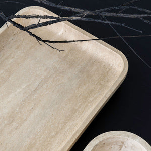 Beige stone trays with black twine on a dark background