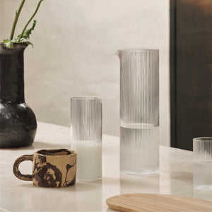 Decorative vases and a mug on a table with a neutral background