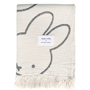 Miffy Cotton Blanket Black, jacquard-woven 100% cotton with fringed short sides and all-over Miffy print.