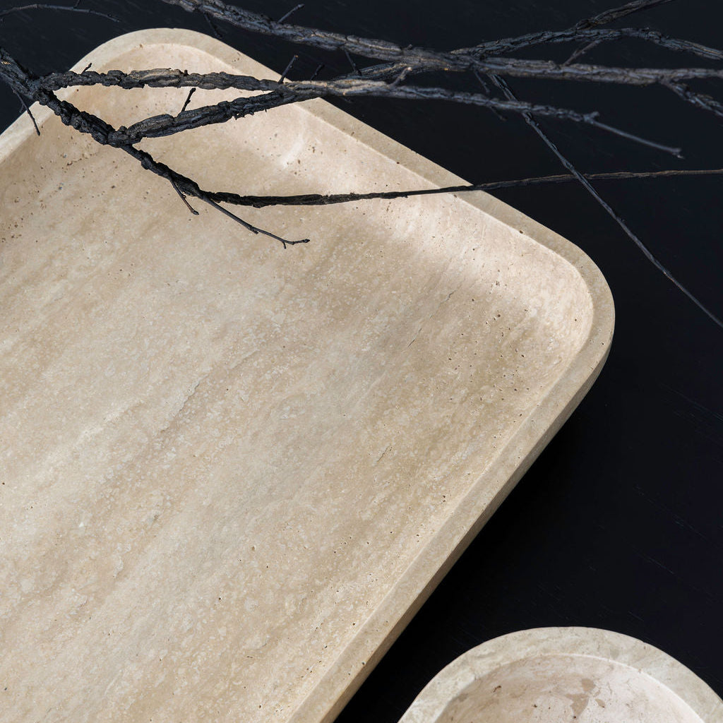 Beige stone trays with black twine on a dark background