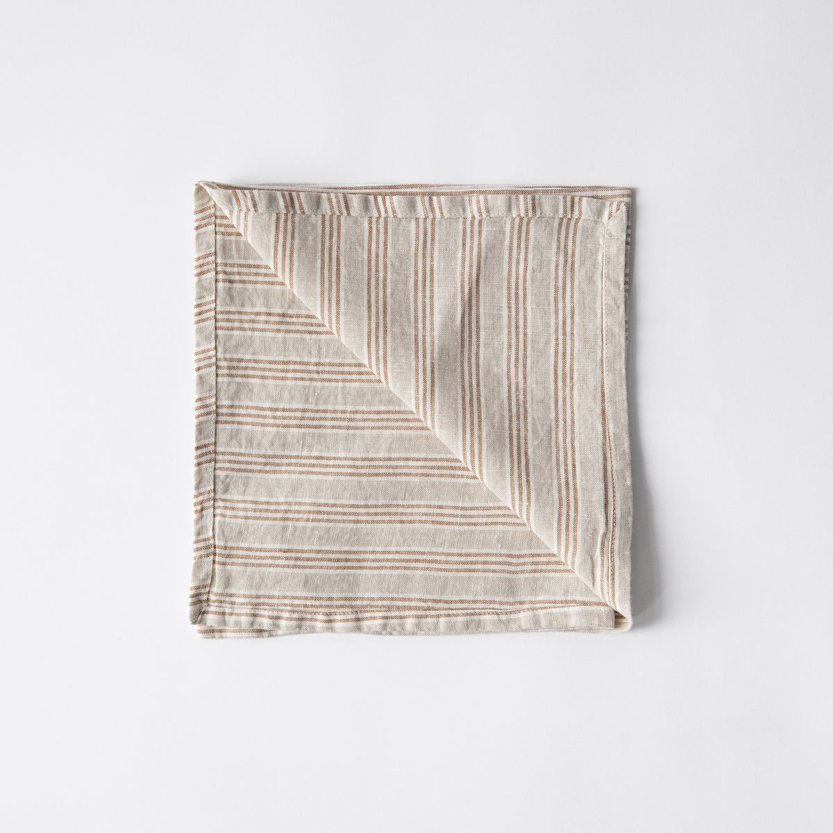 Striped fabric linen square napkin on a light gray background by the brand Tell Me More