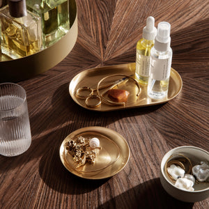 Beverages and small items on a wooden surface with a gold tray.